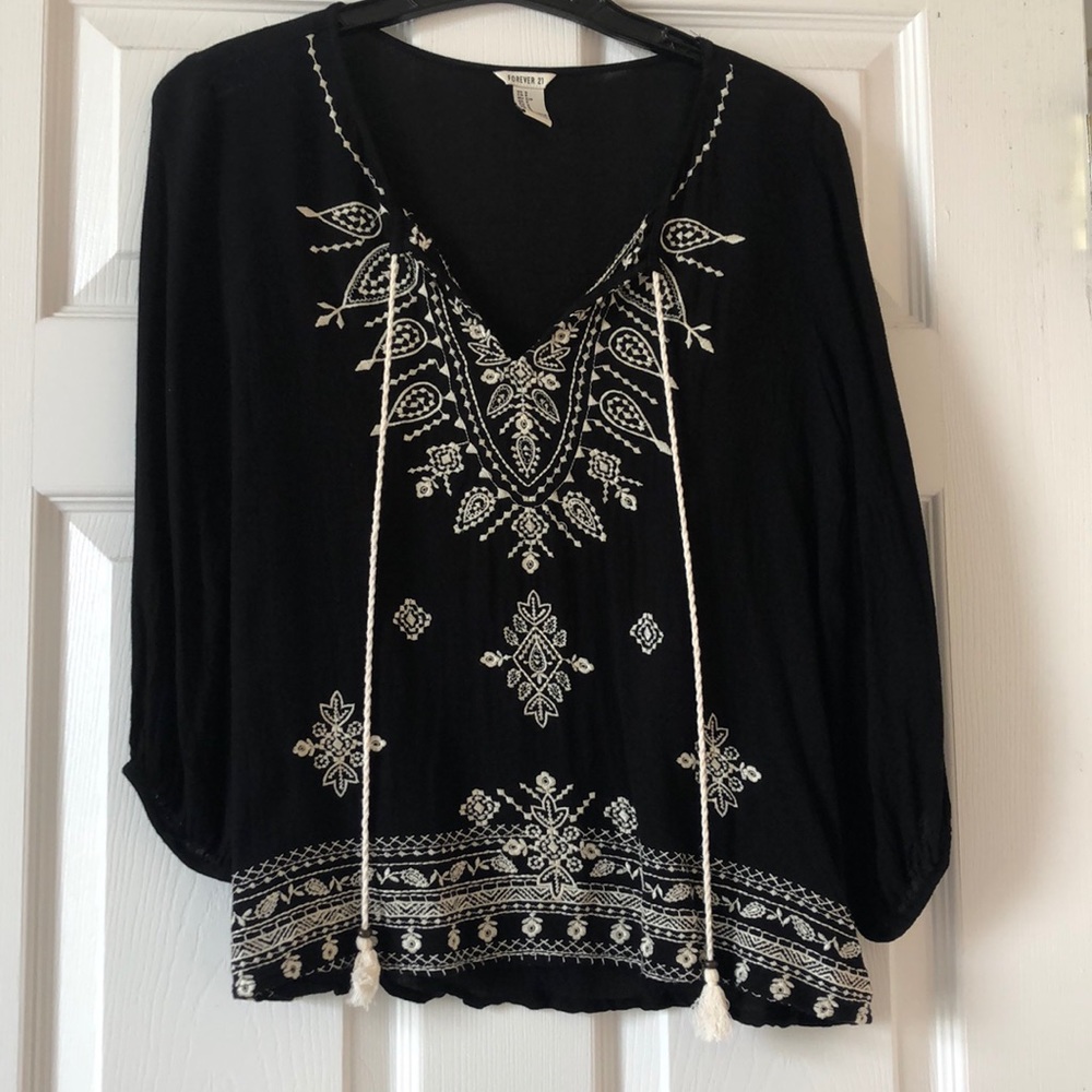 Black v neck top with cream detailing and tassels